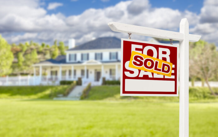 Sold Home For Sale Real Estate Sign in Front of Beautiful New House.