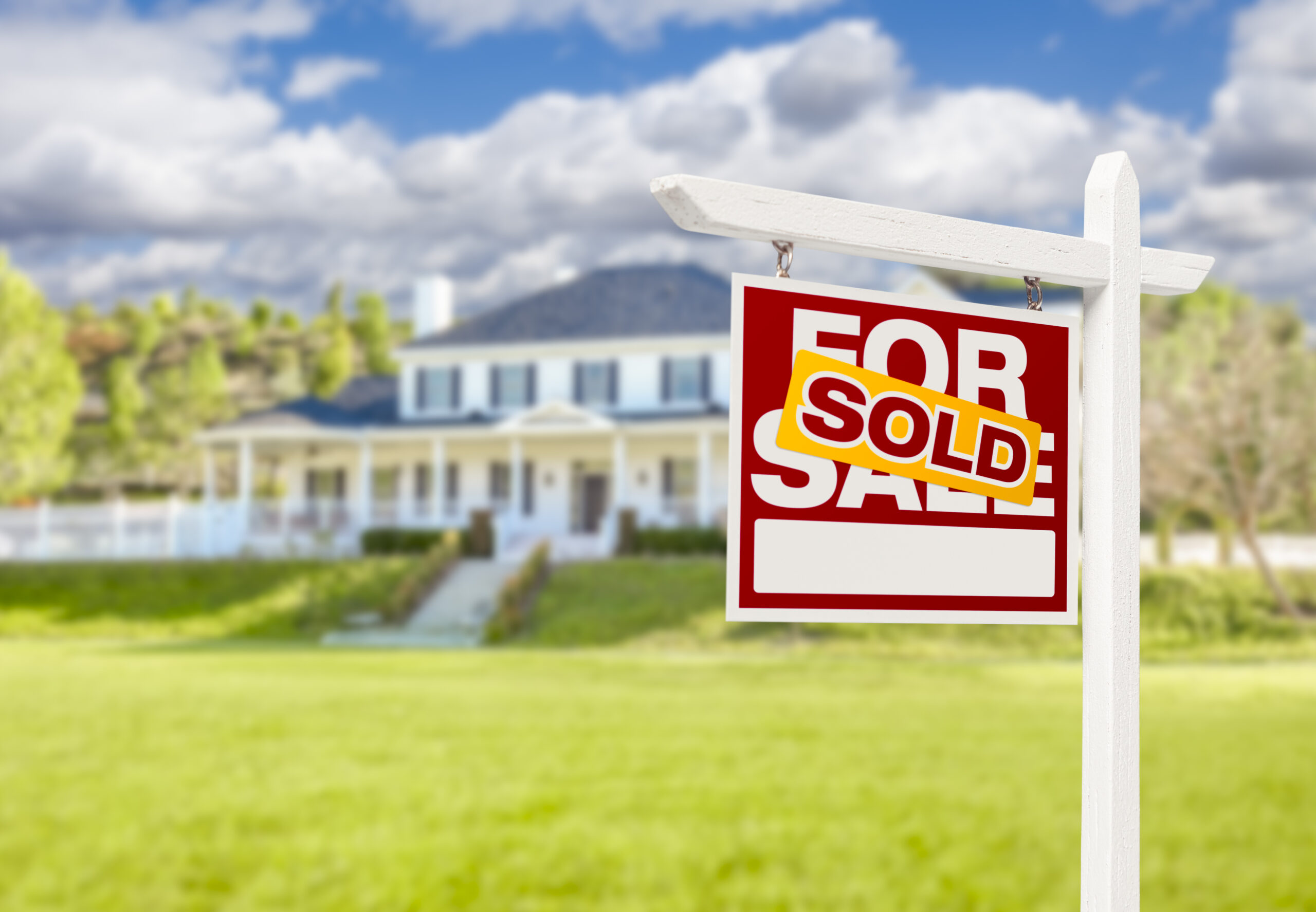 Sold Home For Sale Real Estate Sign in Front of Beautiful New House. Sold Home For Sale Real Estate Sign in Front of Beautiful New House.